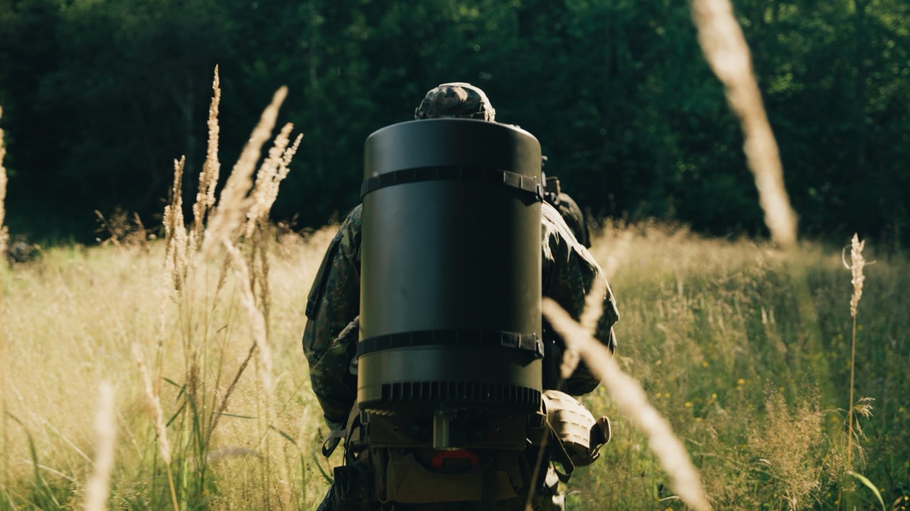 Ein kinoreifes Standbild aus dem Saab L20C Launch-Film, das einen Soldaten zeigt, der sich unauffällig durch ein Feld bewegt und die hohe Mobilität und schwere Entdeckbarkeit der Ausrüstung darstellt.